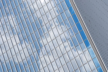 Fototapeta na wymiar Close up detail of reflected glass facade with rectangular windows grid frame system of modern office building. Abstract Architectural Geometry elements background with urban metropolis concept.