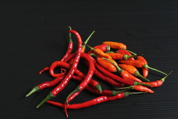 A few of red chilies on the black table.