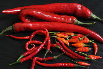 A few of red chilies on the black table.