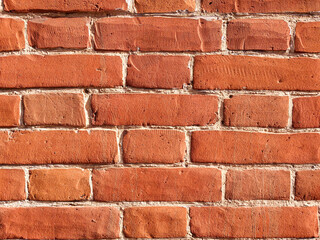 Obraz premium The texture of red antique brick. Background of old red brick wall texture with deterioration from age. The brick wall is lit by the bright sun.