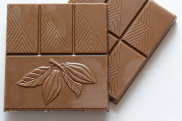 Milk chocolate pieces isolated on white background from top view. Close up a chocolate bar isolated on white background.