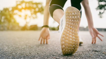 Rear view close up at sport shoes of young athlete woman in starting position which ready to run on...