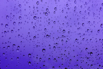 banner of a drop of water on glass in a purple glow. space for text..