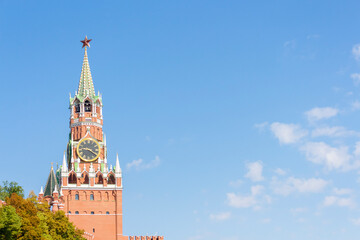 Fototapeta na wymiar View of Spasskaya Tower of Moscow Kremlin on a summer morning. Blue sky with few clouds in the background. Copy space for your text.