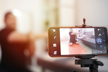 male fitness instructor stream broadcast or record a video lesson on training sport at home for the channel on the internet