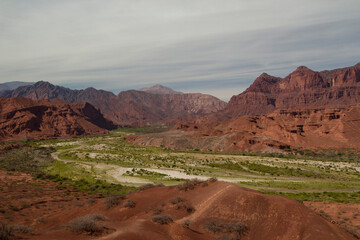 Panorama view of the valley and desert with red mountains and rocky formations.