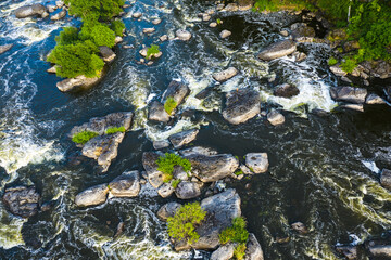 Many rapids with waterfalls, spray foam and whirlpools close-up, rotate the camera. View from drone. Ural region, Russia. The threshold Revun
