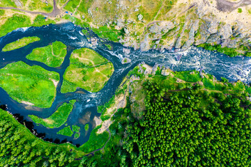 beautiful view vertically down from great height on a beautiful valley with forest and rocks, the mountain river is divided into several streams and Islands. Ural, the threshold Revun.
