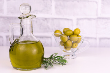 Carafe of olive oil on a table on a white background.