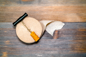 Constipation concept. Roll of toilet paper and a corkscrew on wooden table