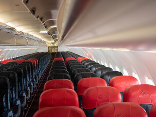 premium and economy seat row in cabin. red and black seat. Outstanding red premium seat among  economy.