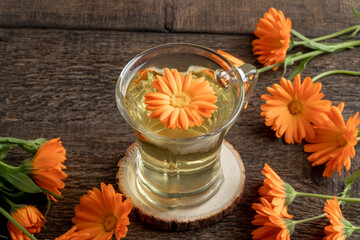 A cup of calendula tea with fresh calendula flowers