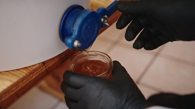 Bee hive interior. Beekeeper draining the honey from the barel. High quality 4k footage