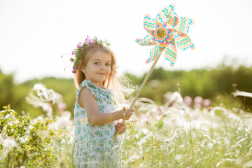 Cute little girl smiling summer in the field holding a baby tinge