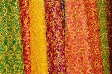 Colorful fabric embroidered with lace and sequins for sale in open-air market, Xishuangbanna, Yunnan Province, China