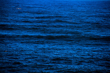 Single boat in the middle of the blue sea