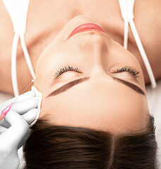 thread lift , cosmetic technique, lifting face skin. Woman having procedure tighten skin on the...