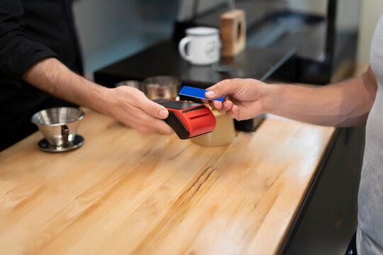 young man paying for his coffee with a credit card