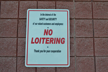 White Sign Outside of a Gas Station Stating "No Loitering"
