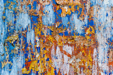 Minimalist colourful textured background of old and rusted whit, blue, brown and orange  paing on metallic surface, in direct sun light in an urban environment.