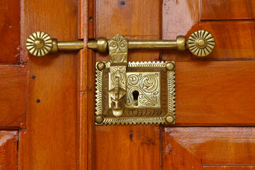 Brass lock on orange door at Asigiriya Maha Vihara monastery, Kandy, Sri Lanka