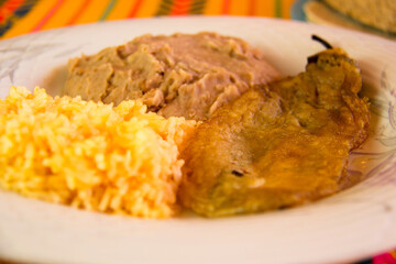 MEXICAN FOOD, CHILLI STUFFED WITH CHEESE WITH RICE AND REFRITED BEANS IN A MEXICAN RESTAURANT