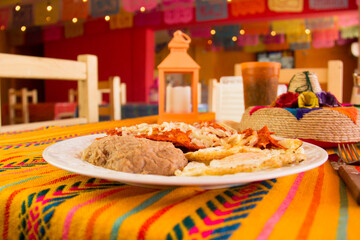 RED CHILAQUILES WITH STARRY EGGS AND REFRITTED BEANS IN A MEXICAN RESTAURANT