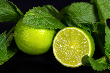 Natural lime and mint leaves on a dark background. Tropical citrus fruits.