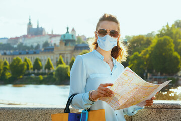 stylish woman with mask, sunglasses and map outdoors in city