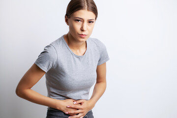 Obraz premium Exhausted young woman suffering from severe abdominal pain