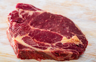 Fresh chop of beef on natural wooden background, nobody