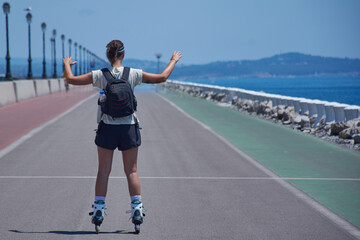 chica joven haciendo deporte con sus patines en linea y su mochila