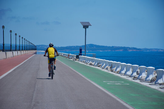 hombre ciclista con maillot amarilo haciendo deporte al lado de mar