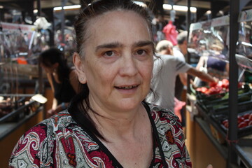 Middle-aged woman buys vegetables at a green market