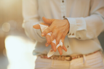 woman sanitising hands with disinfecting wipes outdoors in city