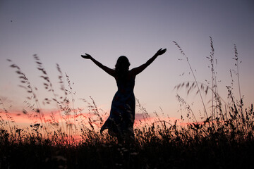 free woman rising arms in sunset
