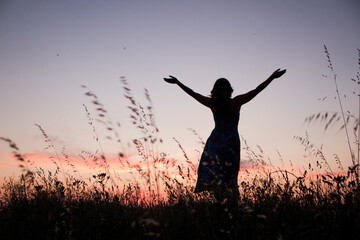 free woman rising arms in sunset