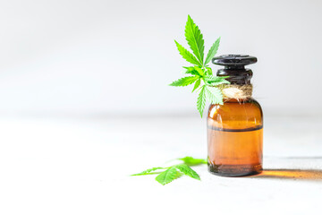 Glass bottles of hemp oil with hemp leaves.