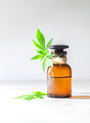Glass bottles of hemp oil with hemp leaves.