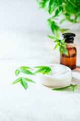 Hemp oil cosmetics on a light gray concrete background.