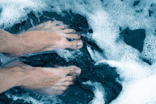 Male Feet On Black Sand Beach Shore