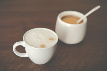 small cup with cappuccino next to sugar bowl
