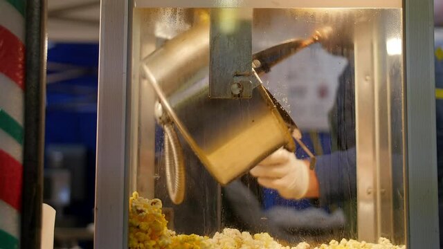 Hand dumps kettle of fresh popcorn