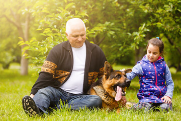 Grandfather And Granddaughter Taking Dog For Walk
