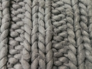 Detail of a rustic handmade chunky rug. Knitted wool background.