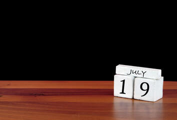 19 July calendar month. 19 days of the month. Reflected calendar on wooden floor with black background