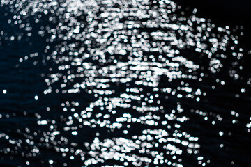 Glare on water, Bokeh on water, blurred and unfocused background.