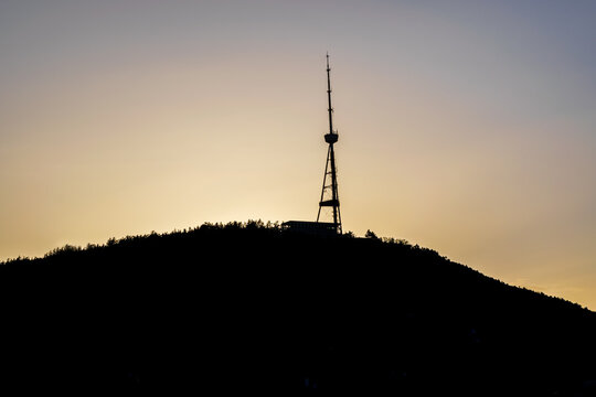 Cityscape of Tbilisi with the silhouette of Mount Mtatsminda and Tbilisi TV Broadcasting Tower during the colorful sunset. Tbilisi, Georgia