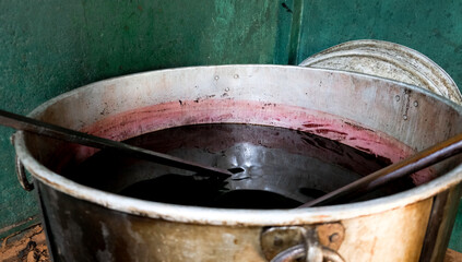 Fototapeta premium Ayurvedic natural oil treatment preparation process at a spice factory in Sri Lanka. Tank with fluid medicine in a Spice Garden in Kandy.