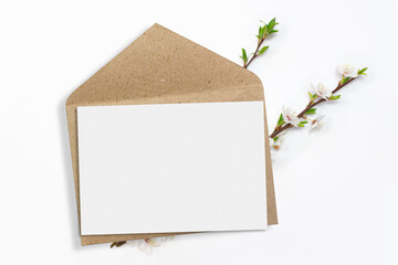 Invitation card and craft paper envelope with cherry branch blossom on clean white background minimalist clean mockup